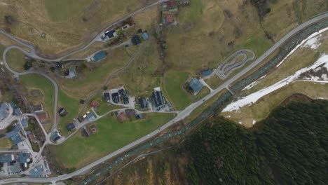 Saalbach-Hinterglemm-ski-resort-with-winding-roads-and-green-slopes,-aerial-view