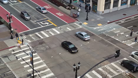 Cars-driving-over-an-intersection-in-the-city-centre-of-Oakland-at-daylight