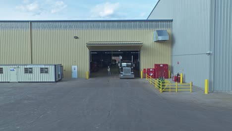 Aerial-pullback-from-semi-truck-in-large-loading-dock-inside-of-steel-warehouse
