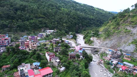 Luftpanorama-Von-Dorfhäusern-Am-Ufer-Des-Gandaki-Flusses-Mit-Blick-Auf-Die-Berge,-Drohnenflug-über-Marpha-In-Nepal