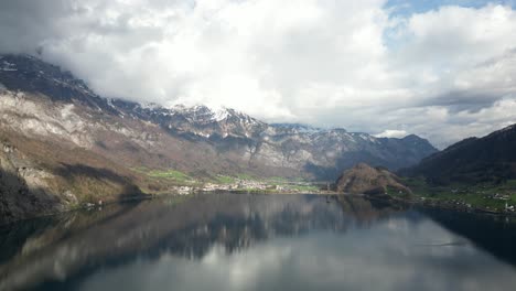 Panoramic-View-Of-Famous-Walensee-Unterterzen-Lake-In-Front-of-Snowy-Mountains-In-Switzerlan