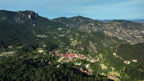 Drone-flying-away-from-the-Mineral-del-Chico-village,-in-sunny-Hidalgo,-Mexico