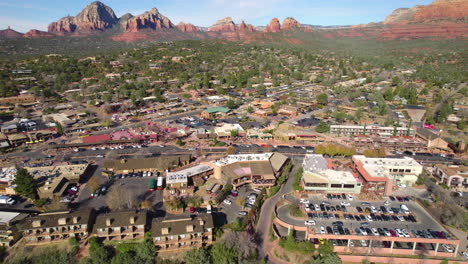 Downtown-Sedona,-Arizona-USA,-Drone-Shot-of-Traffic-and-Buildings-in-Scenic-Valley-Under-Red-Sandstone-Hills