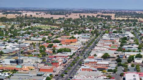 Aerial-alongside-two-telecommunications-towers-and-down-the-Yarrawonga-main-street-with-cars-and-buildings