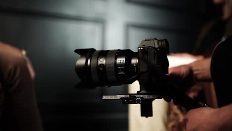 Cameraman-prepare-digital-camera-on-gimbal-stabilizer,-indoor-studio