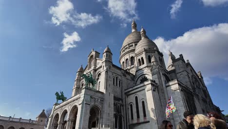 Crowd-of-people-at-Sacre-Coeur-with-blue-sky-in-background,-Montmartre-in-Paris,-France