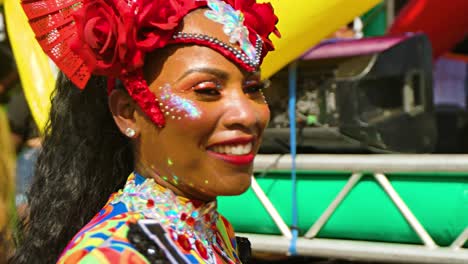 Schwarze-Frau-Hebt-Lächelnd-Klares-Glas,-Während-Sie-In-Der-Karnevalsparade-Tanzt