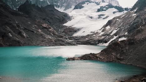 Tilt-up-Reveal-Of-Glacier-And-Mount-Fitz-Roy-Across-Laguna-de-los-Tres-In-El-Chalten,-Argentina