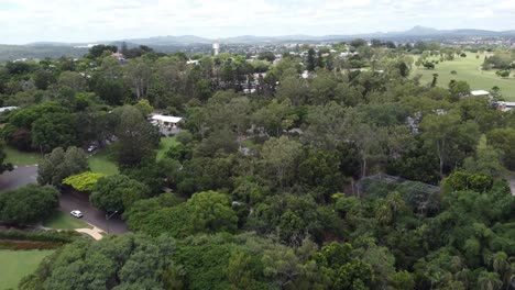 Aerial-view-of-a-large-green-park-with-a-small-city-views-in-the-background