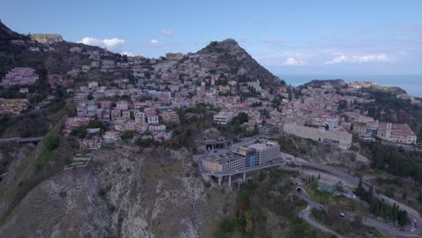 Luftaufnahme-Einer-Weiten-Umlaufbahn-über-Taormina,-Sizilien,-Italien,-Eine-Südseite-Der-Stadt-Auf-Dem-Felsen
