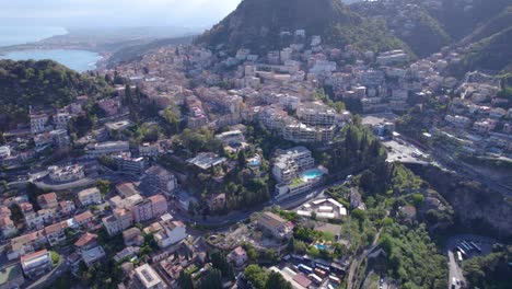 Aerial-establishing-shot-of-the-north-side-of-Taormina,-Sicily,-Italy-a-famous-tourist-destination
