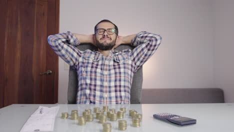 Man-doing-accounting-and-counting-money-coins-makes-a-happy-satisfaction-face