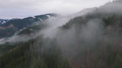 Misty-forest-on-the-slopes-of-Saalbach-Hinterglemm-ski-resort,-Austria,-aerial-view