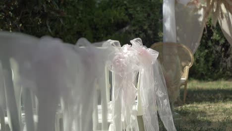 Toma-Lenta-Y-Reveladora-De-Sillas-Decoradas-Listas-Para-Una-Recepción-De-Boda-En-El-Exterior.