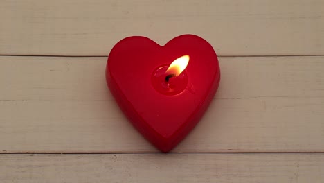 Red-heart-shaped-candlelight-on-wooden-background.Video-4K