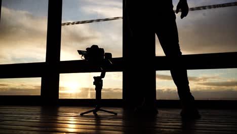 Person-silhouette-calibrate-gimbal-stabilizer-in-studio-during-golden-hour