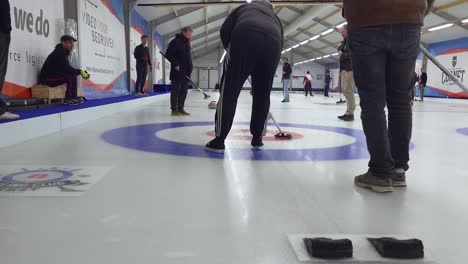 Jugador-Cepillando-Curling-Con-Escoba-Fuera-De-La-Casa-Sobre-Hielo