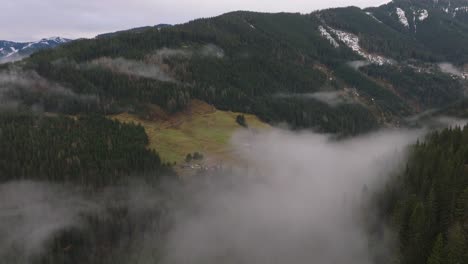 Misty-mountains-with-green-slopes-in-Saalbach-Hinterglemm,-Austria,-aerial-view