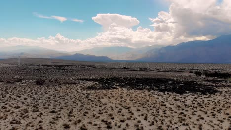 Empuje-Lento-Sobre-Maleza-Del-Desierto-Y-Drones-De-Molinos-De-Viento-Cerca-De-Palm-Springs,-California