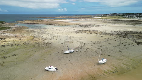 Abwärts-Gerichtete-Dolly-Luftaufnahme-Von-Drei-Kleinen-Booten,-Die-Bei-Ebbe-Am-Sandstrand-Ruhen