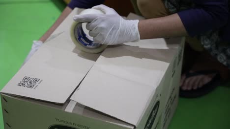 Cinematic-Shot-man-packing-the-big-savory-food-box-with-tape-and-taking-it-to-the-Warehouse