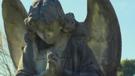 Gimbal-tracking-left-around-a-stone-angel-statue-in-a-graveyard-on-a-sunny-day