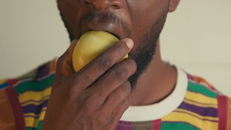 Close-Up-Of-A-Bearded-Afro-American-Man-Biting-And-Chewing-Green-Apple-In-Slow-Motion