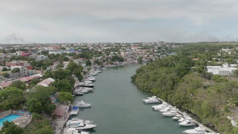 Luftaufnahme-über-Dem-Kanal-Des-Hafens-Von-La-Romana-Mit-Booten,-Die-Entlang-Des-Flussufers-Vor-Anker-Liegen,-Dominikanische-Republik