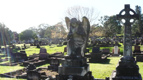 Drohne-Fliegt-An-Einem-Sehr-Sonnigen-Tag-Um-Eine-Steinerne-Engelsstatue-Auf-Einem-Friedhof