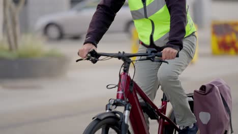Man-cycling-through-streets-in-a-slow-motion-tilting-shot
