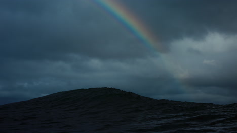Regenbogen-Wölbt-Sich-über-Grauem-Gewitterhimmel-Blick-Von-Der-Rückseite-Der-Welle-In-Kaltem-Wasser
