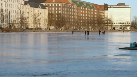 Friends-in-Helsinki-park-play-casual-hockey-game-on-skating-rink-ice