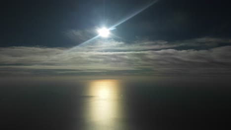 Dramatic-winter-sky-with-a-white-and-yellow-sun-veiled-by-some-frayed-clouds