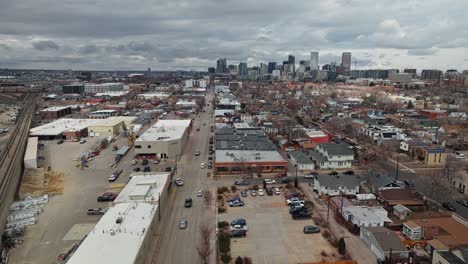 Cars-drive-down-one-way-street-in-industrial-district-outskirts-of-Denver-Colorado-on-overcast-day,-panoramic-orbit