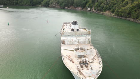 Dolly-and-Overhead-View-of-Large-Derelict-Boat-Floating-on-Body-of-Water-with-seagulls-flying