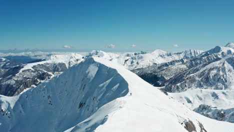 Schneebedeckte-Berggipfel-Unter-Einem-Klaren-Blauen-Himmel,-Panoramaaufnahme-Bei-Hellem-Tageslicht