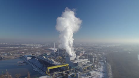 Aerial-approach-to-the-coal-fired-heating-power-station-with-thick-white-smoke-coming-from-the-chimney,-environmental-pollution-concept