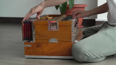 Indian-Harmonium-Musical-Instrument-Played-Pumped-Manually-By-Musician-Crouching-On-Floor