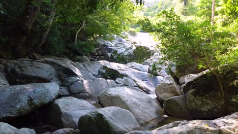 Agua-De-Corriente-Natural-Que-Fluye-Entre-Rocas-Durante-El-Día-Soleado-En-La-Selva-Amazónica-Colombiana