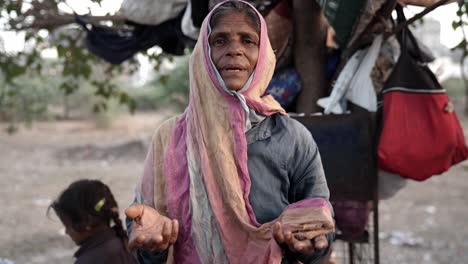 Cinematic-Shot-An-old-Woman-is-talking-to-the-camera-and-his-boys-are-playing-in-the-background