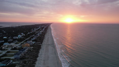 Drone-shot-of-sun-rising-over-the-ocean-in-Emerald-Isle,-NC