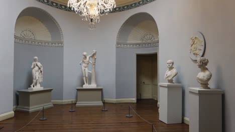 Toma-Panorámica-De-Una-Sala-De-Museo-Llena-De-Antiguas-Estatuas-Romanas-Blancas.