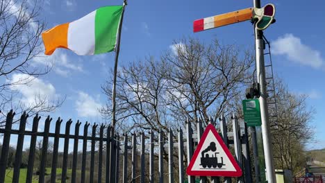 Irish-flag-old-railway-signal-and-train-sign-and-blue-sky-Kilmeaden-Station-Waterford-Ireland