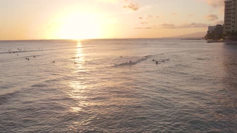 Los-Surfistas-Disfrutan-Del-Pintoresco-Atardecer-De-La-Hora-Dorada-En-La-Bahía-De-Waikiki,-Isla-De-Oahu,-Hawaii