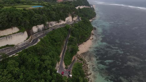 Aerial-view,-cliffside-asphalt-road-and-sea-located-on-Tanah-Barak-beach,-Bali-island,-Indonesia