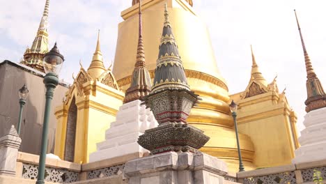 looking-up-at-towering-detailed-golden-pagoda-spires-in-a-buddhist-temple-complex-in-the-Rattanakosin-old-town-of-Bangkok,-Thailand