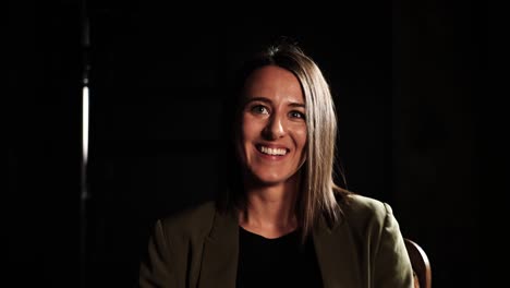 Foto-De-Cabeza-Parlante-De-Una-Mujer-Durante-Una-Entrevista-Tipo-Estudio-En-Un-Ambiente-Oscuro