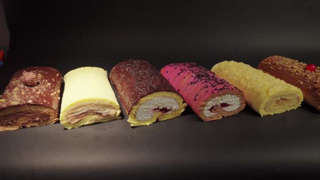 Kuchenrollen-Brazo-Gitano-Biskuitrolle-Desserts-Sammlung-Schokolade-Ferrero-Käse-Butter-Gelee-Beeren-Kirsche-Mit-Schwarzem-Hintergrund
