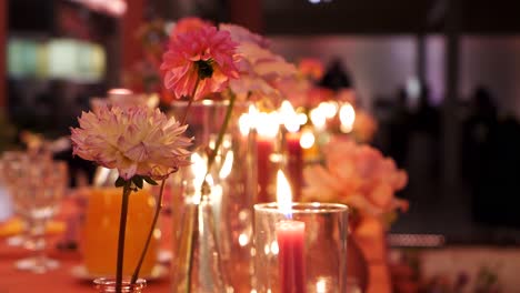 Rosa-Blumen-Vor-Dem-Hintergrund-Brennender-Kerzen-In-Glasbehältern