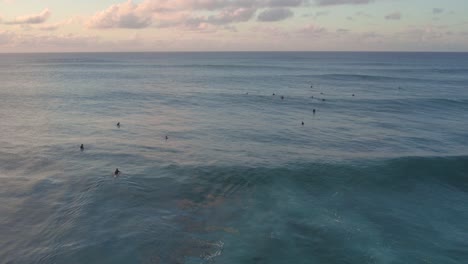 Surfistas-Surfeando-En-La-Costa-Norte-De-Hawaii-Durante-La-Puesta-De-Sol,-Toma-Aérea
